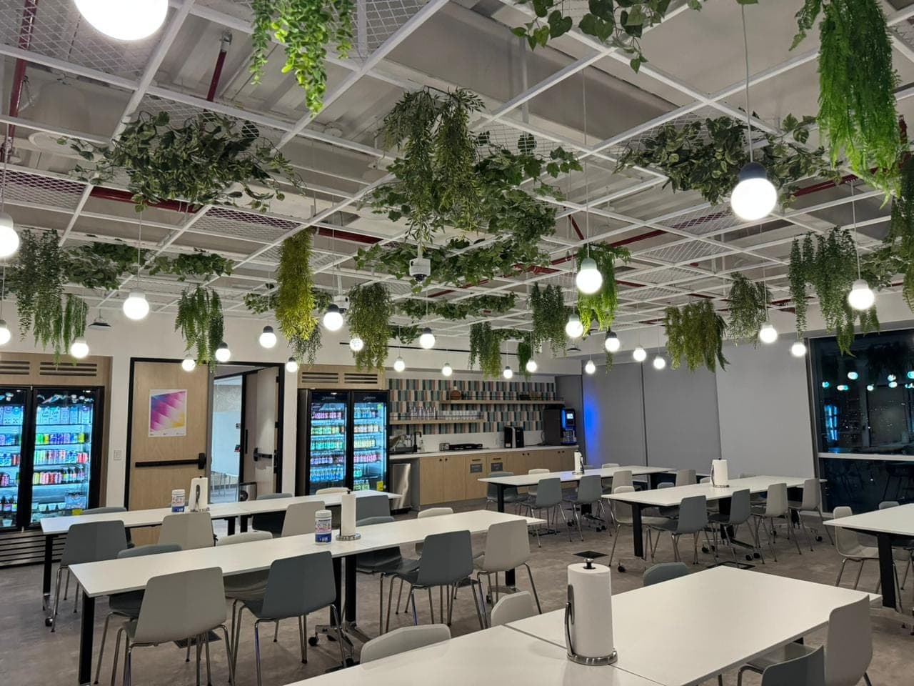 Gran comedor biofílico con plantas y péndulos redondos