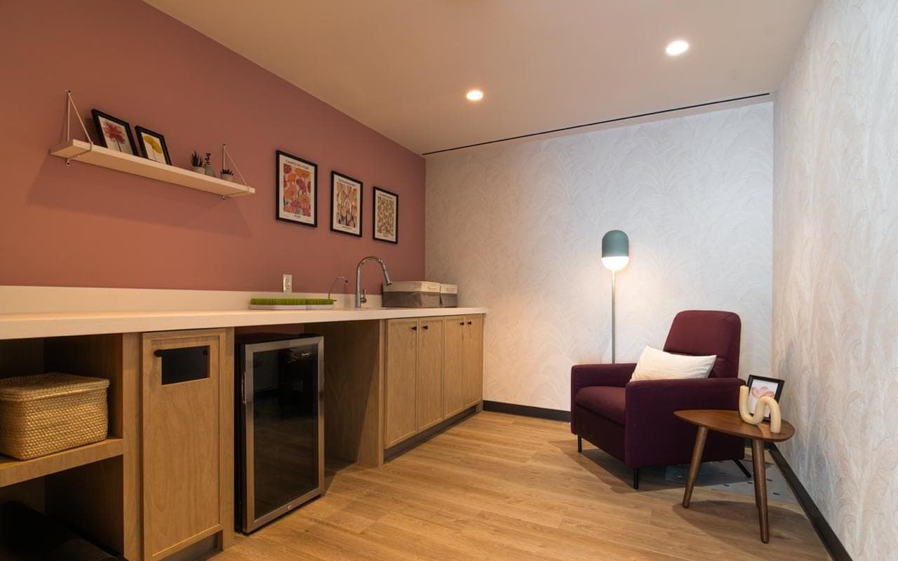 Rincón de lectura con muro rosa palo y lámpara de piso